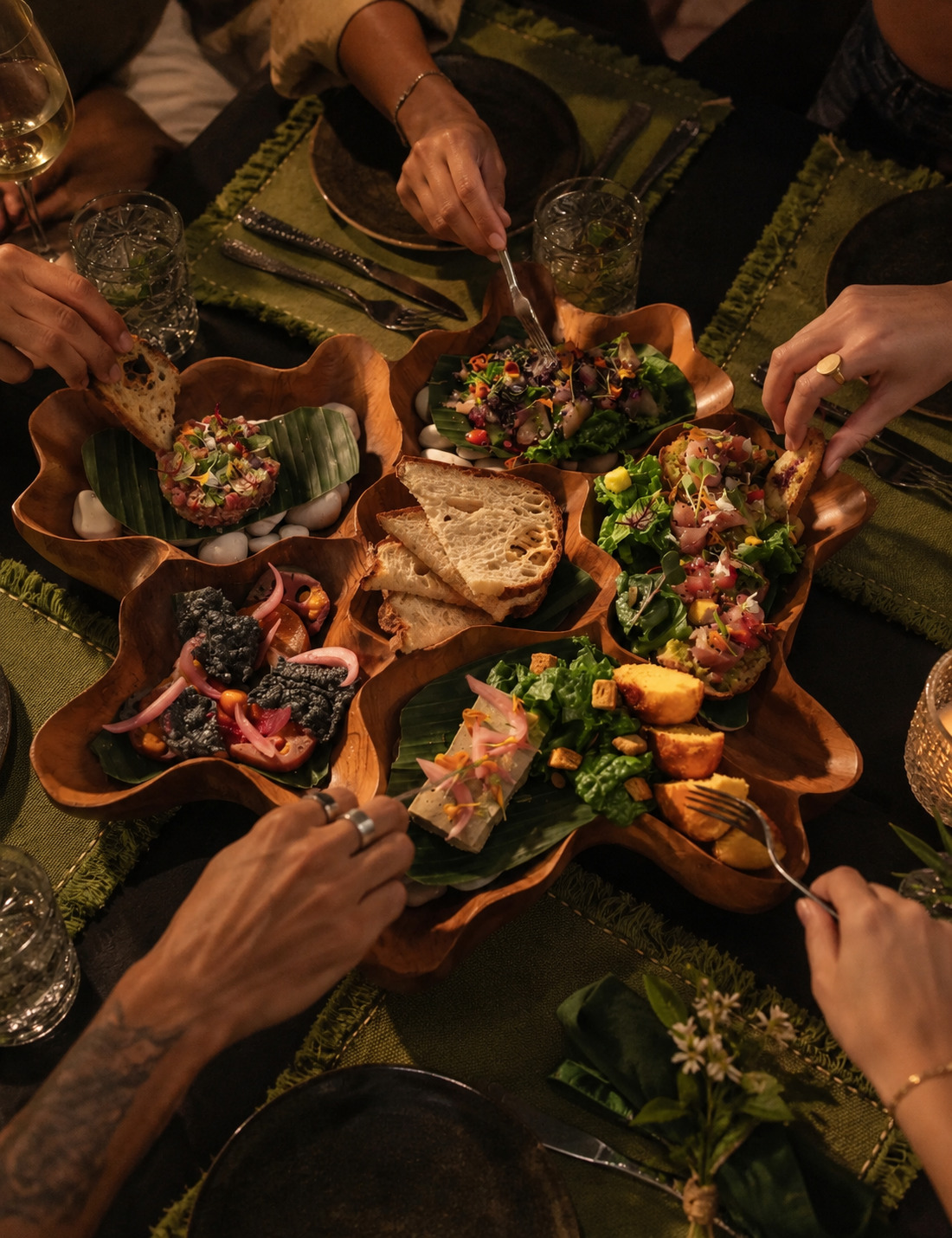The sharing board at Orama, hands reaching across the table for tartares, salads and bread